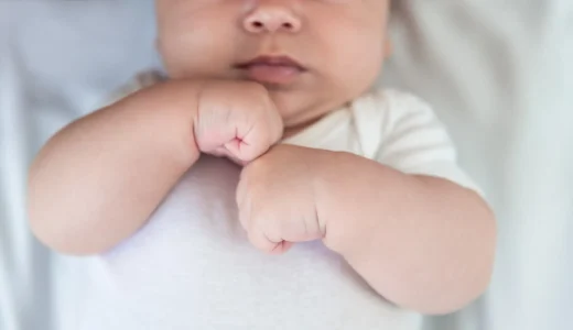 hands-of-little-baby-on-white-sheet-bed-background-2024-12-07-13-04-09-utc